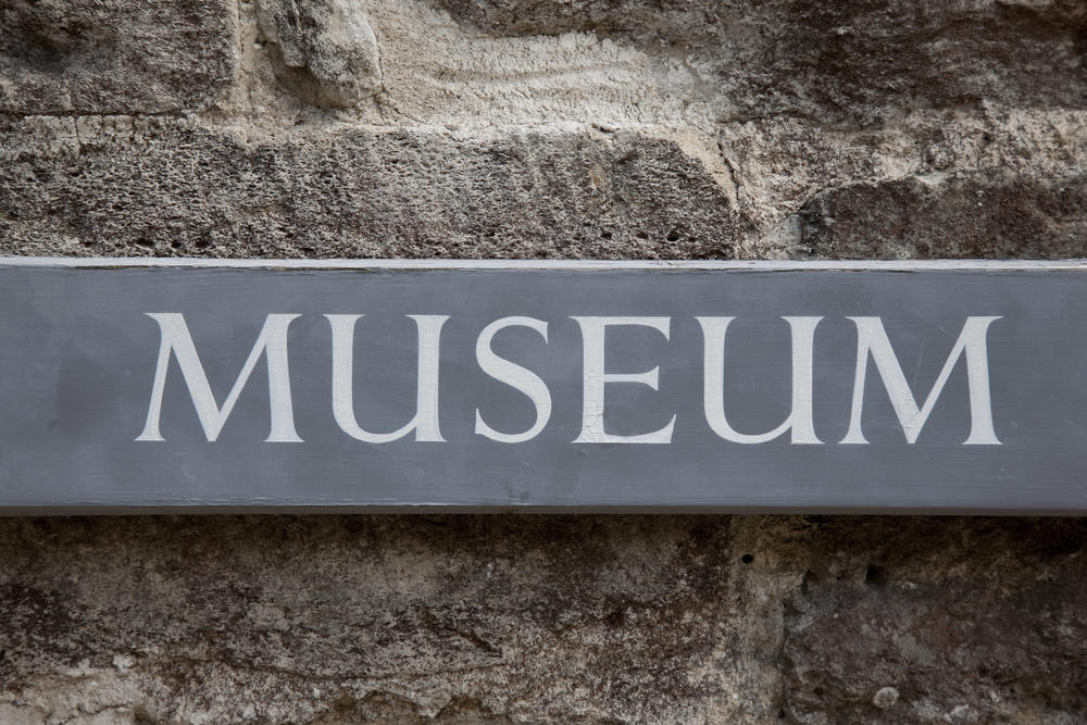 panneau de musée en bois gris sur pierre