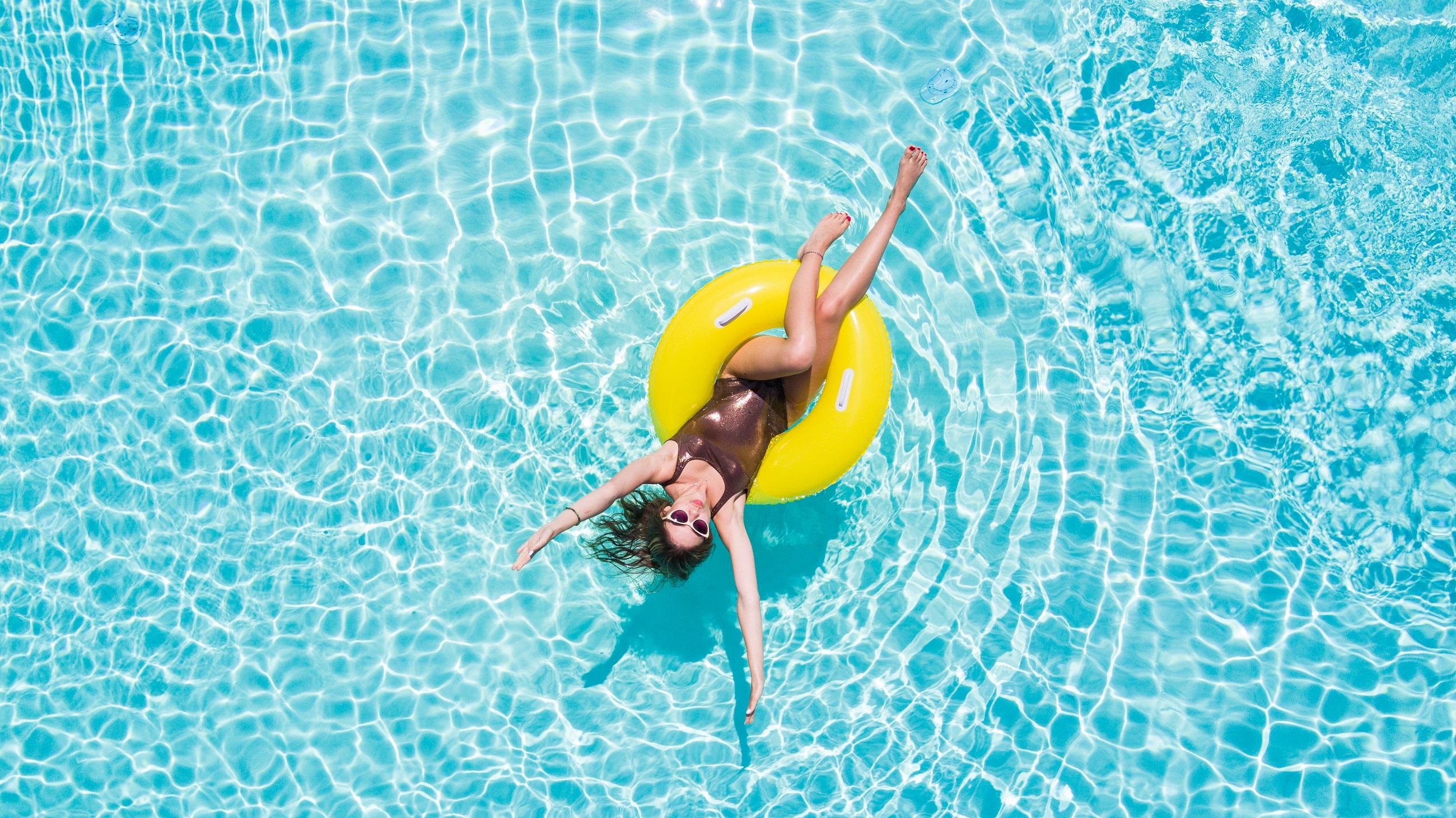 Meisje in een zwarte bikini in een gele ring in het waterpark