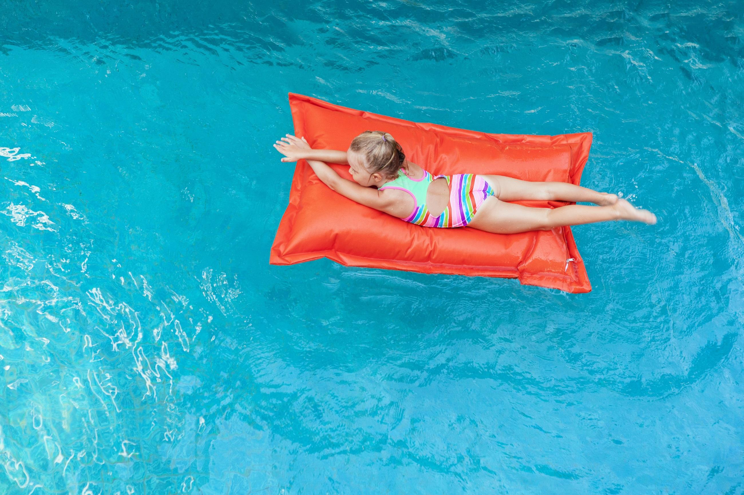 Meisje op een klein rood matras in het waterpark