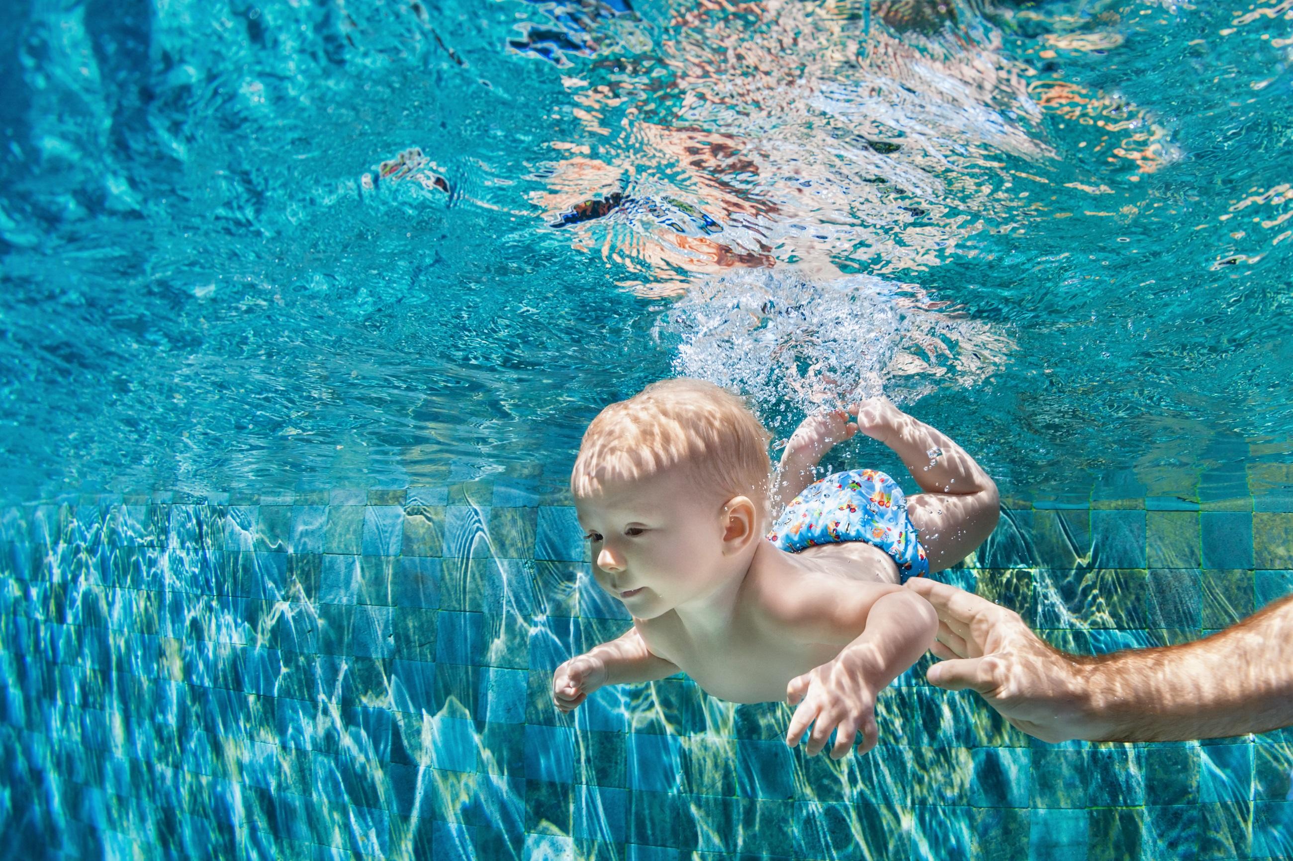 Kleiner Babyjunge unter Wasser im Wasserpark
