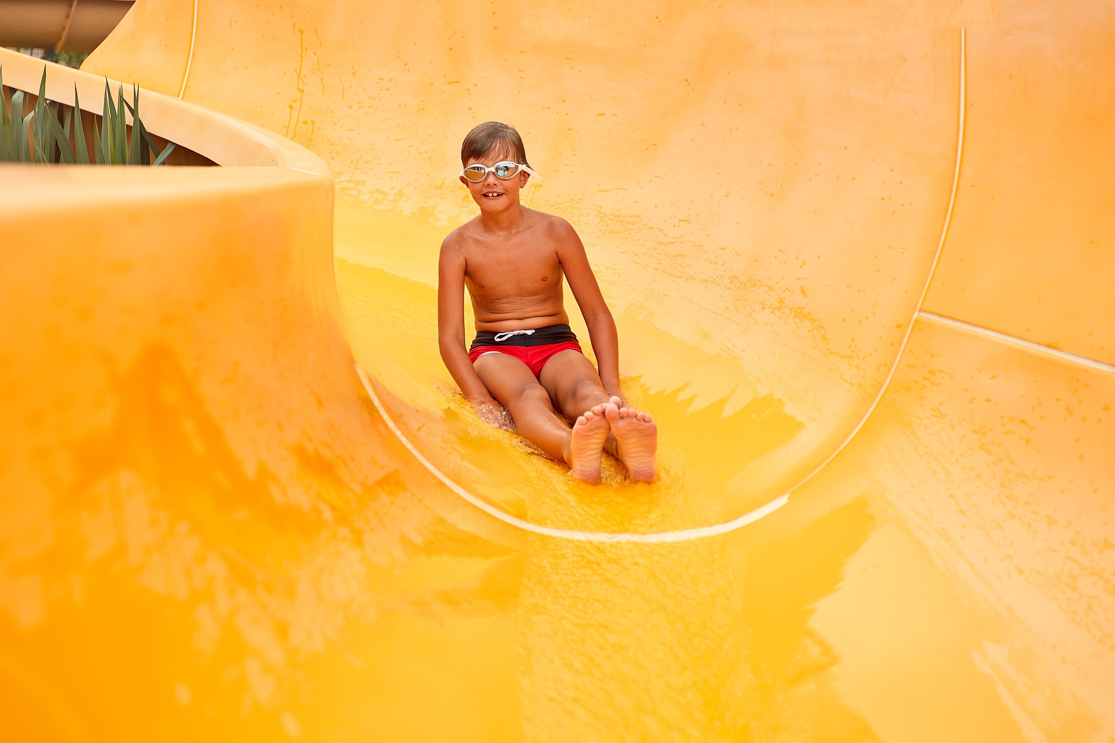 parc aquatique petit garçon toboggan jaune