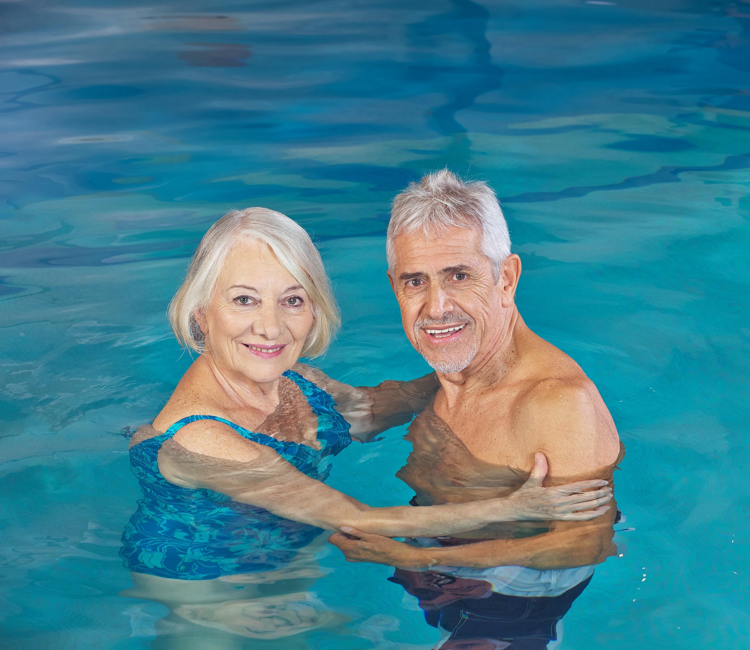 Personne âgée souriante dans une piscine