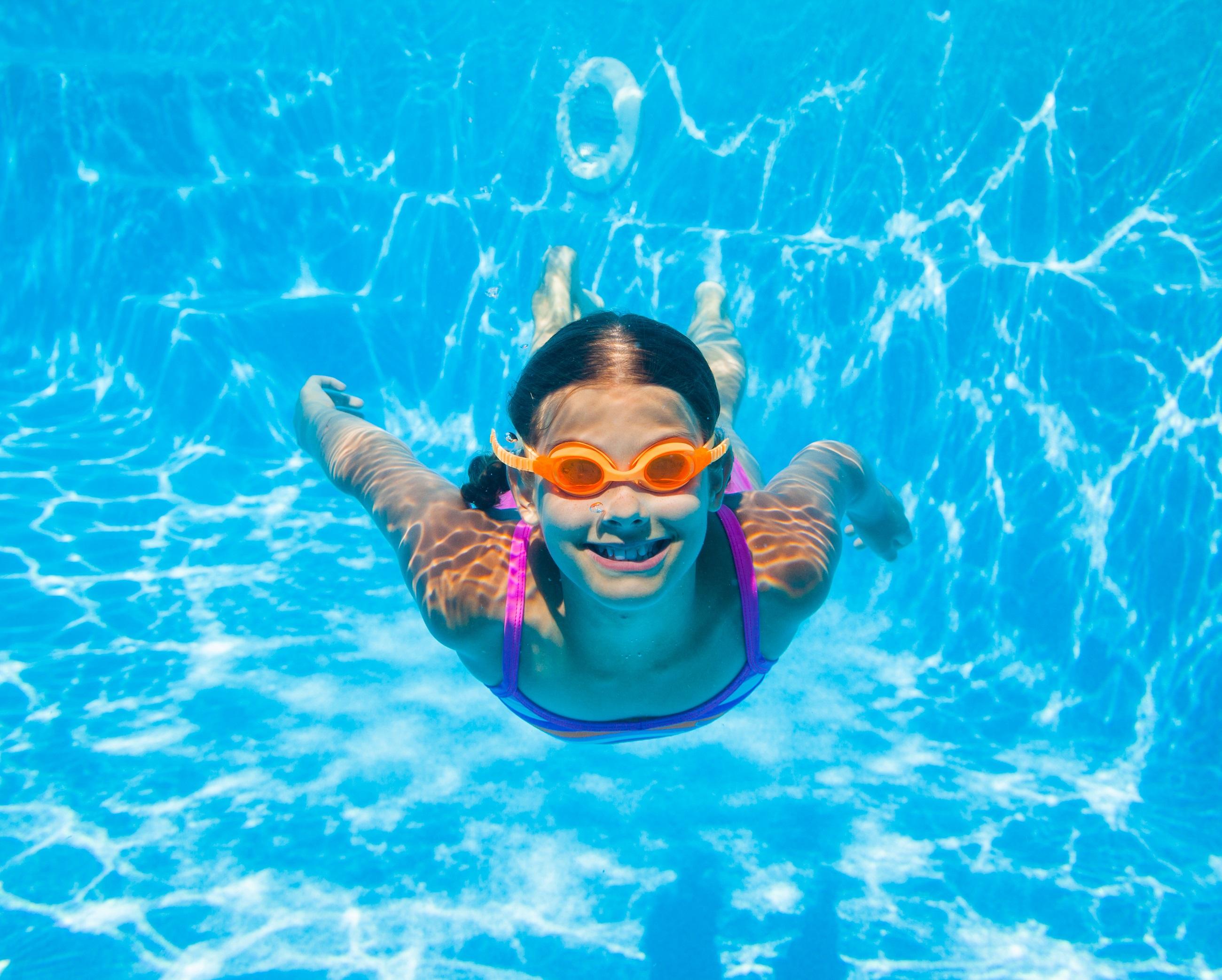 Zwemmend meisje onder water in het waterpark