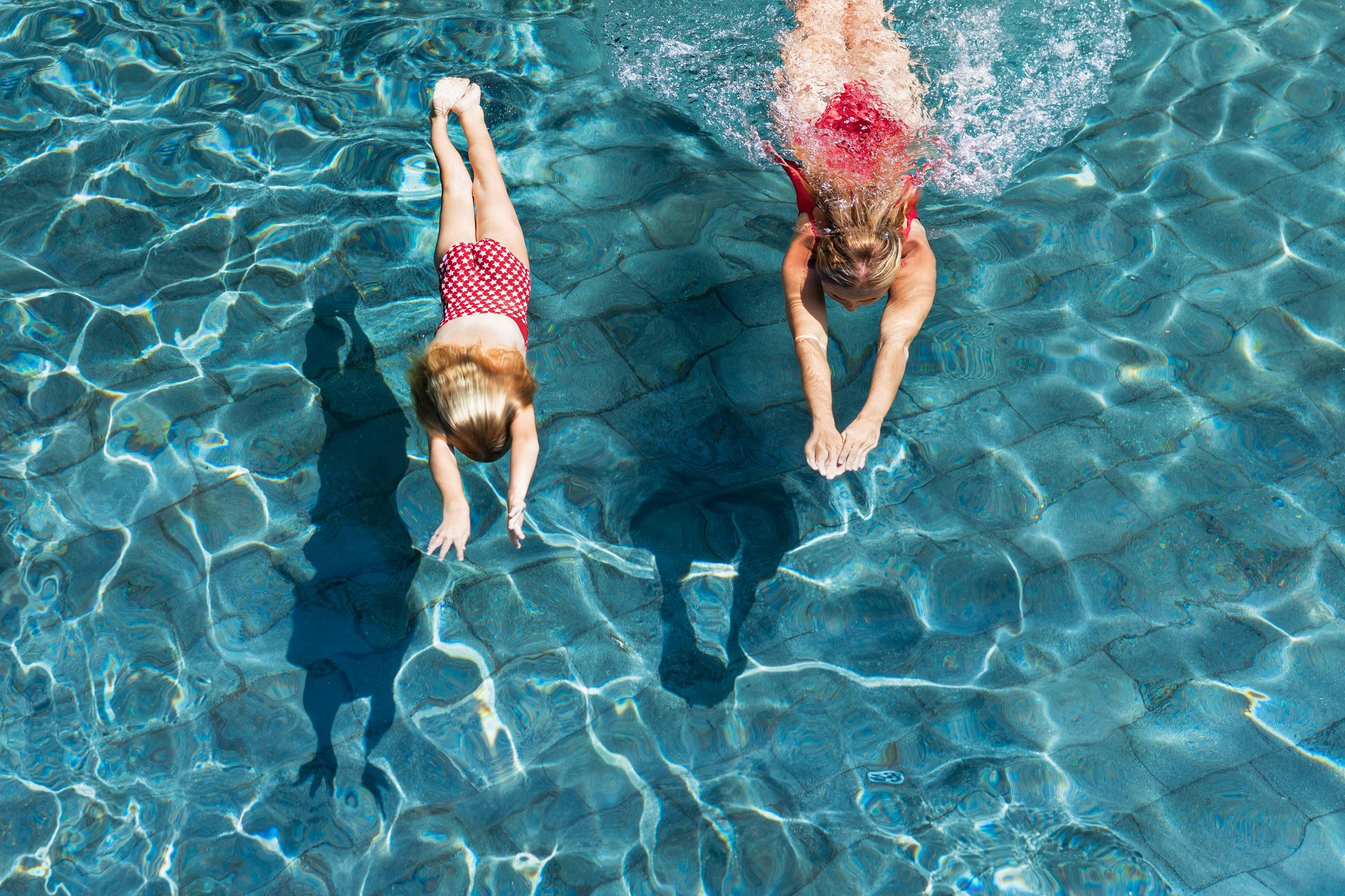 Zwei Schwestern in rosa Badeanzügen im Wasserpark