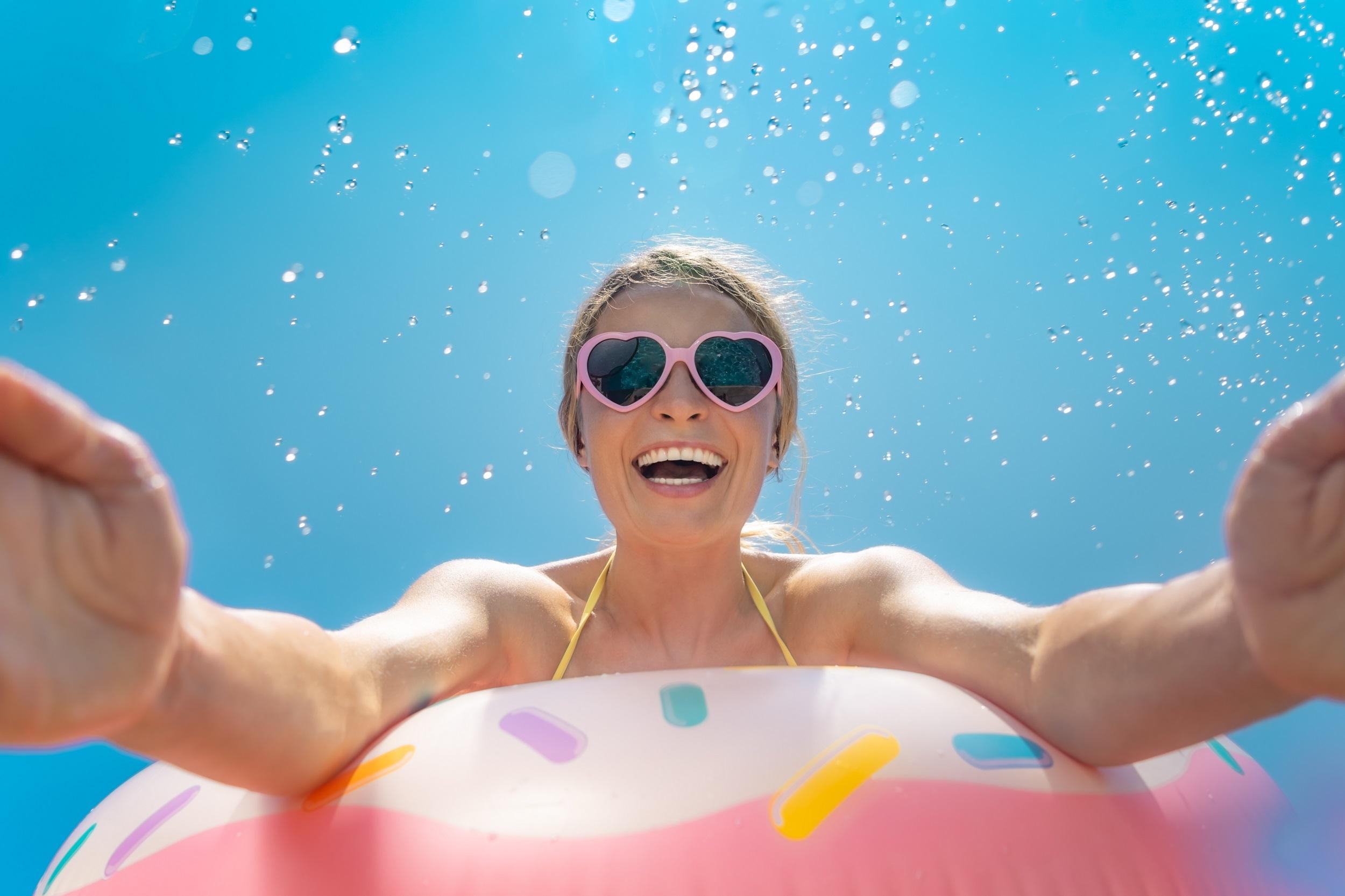 Femme au parc aquatique avec des lunettes de soleil roses